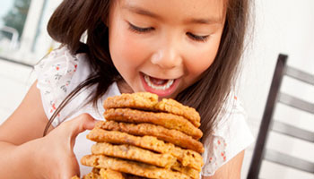 A young girl eating cookies