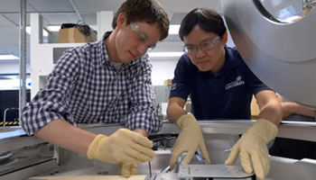 Two engineers repairing high-tech wafer fabrication equipment. 
