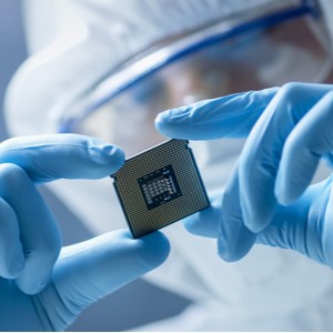 A human looking closely at a microchip
