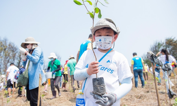 Child holding a sapling for planting