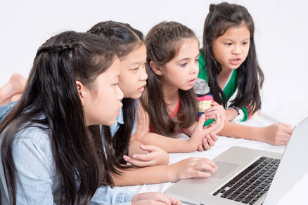 girls looking at single computer